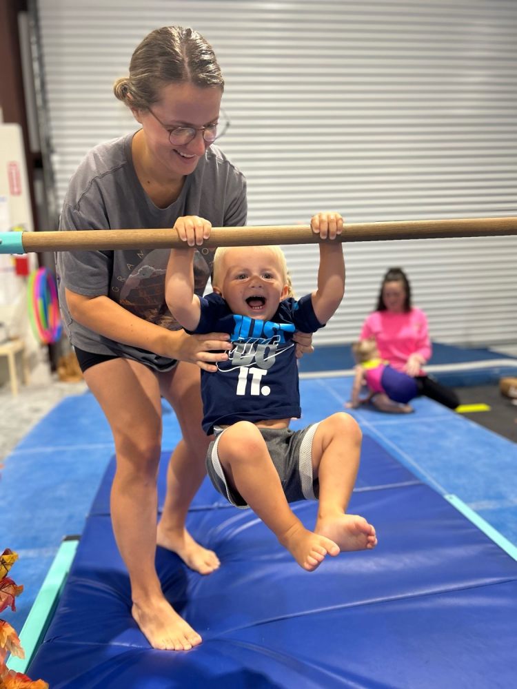 Toddler boy using bar at Riverfront Gymnastics class